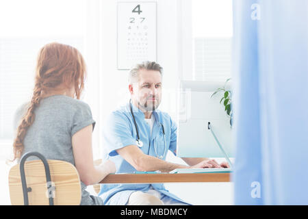 Professional doctor examining his female patient in a medical clinic Stock Photo