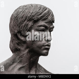 Los Angeles, CA, USA - April 5, 2018: Bruce Lee statue in Central Chinatown. Closeup of his face. Silver sky. Stock Photo