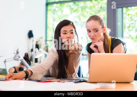 Tailor women or fashion designers work on draft at notebook Stock Photo