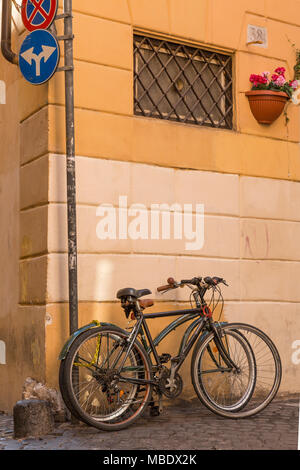 Two bikes locked up on a street corner in the Trastevere part of Rome, Italy. Cycling is a popular way to get around the city for both tourists and lo Stock Photo