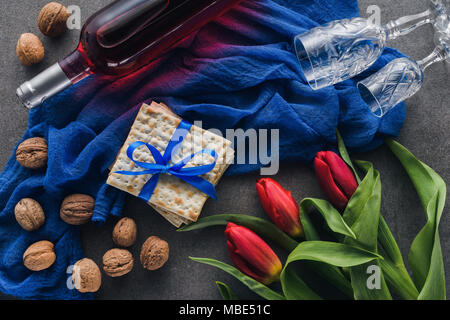 top view of red tulips, wine and matza on table, Pesah celebration concept Stock Photo