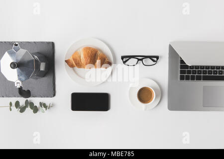 flat lay with digital devices and breakfast on white tabletop Stock Photo