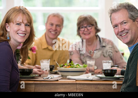 Two senior couples getting together for a dinner party. Stock Photo