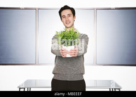 Caucasian businessman holding an office plant in his hands. Stock Photo