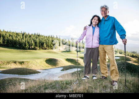 A young asian senior couple playing golf. Stock Photo