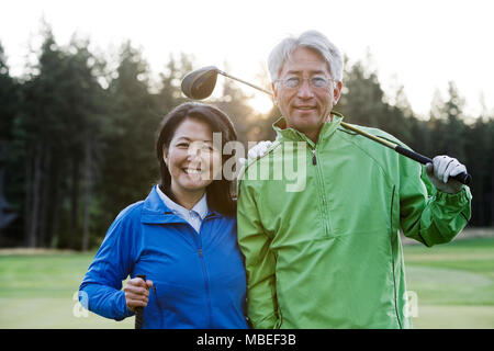 A young asian senior couple playing golf. Stock Photo