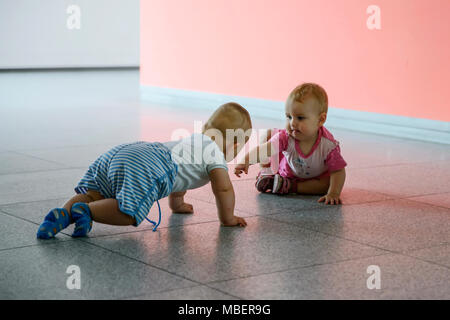 Little boy in blue clothes and little girl in pink clothes play Stock Photo