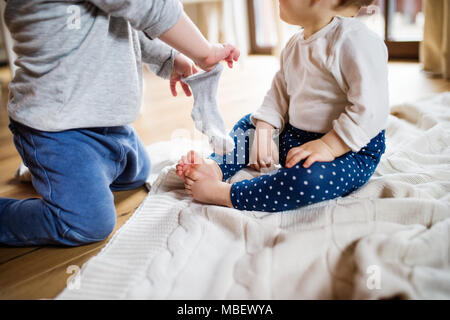 Two unrecognizable toddler children playing at home. Stock Photo