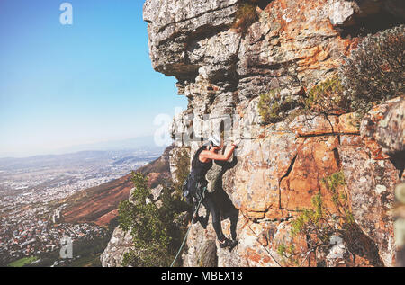 Female rock climber hanging from rock Stock Photo