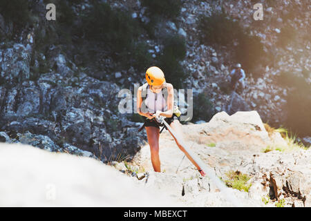 Female rock climber rappelling rock Stock Photo