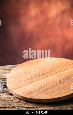 Empty pizza round board  old wooden table and colour blurred background. Stock Photo