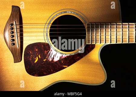 Detail of folk acoustic guitar on a black background. Stock Photo