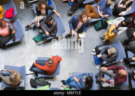 Overhead view conference audience listening to speaker with microphone Stock Photo