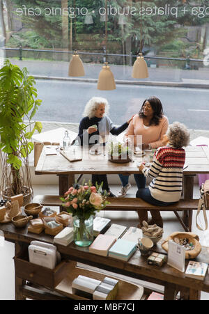 Women friends talking, drinking tea in shop Stock Photo