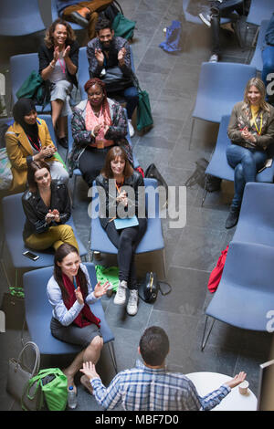 Conference audience clapping for male speaker Stock Photo