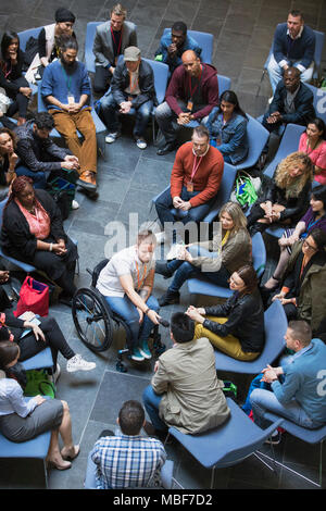 Overhead view female speaker in wheelchair giving microphone to audience Stock Photo