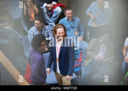 Smiling businessmen talking at conference Stock Photo