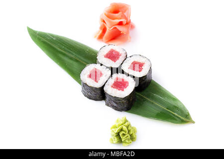Delicious fresh mini-rolls with tuna on a banana leaf. Sushi rolls on a white background with ginger and wasabi. The Japanese menu. Stock Photo
