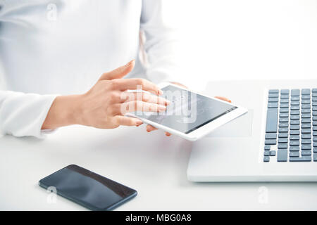 Close-up of businesswoman's hand typing password on her digital tablet while signing in and checking emails. Isolated on white background. Stock Photo