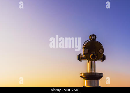 Binoculars isolated on a beautiful evening orange, purple blue graduated sky with large copy space. Stock Photo