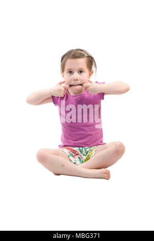 young girl sat on floor pulling a face Stock Photo