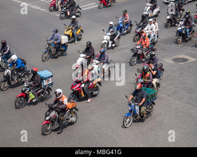 People on mopeds, motorbikes and scooters on a crowded road in heavy traffic on a Bangkok city street in Thailand Asia Stock Photo