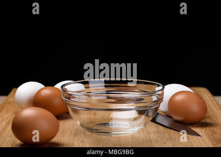 Eggs for omelets. Eggs, a knife, a bowl on a cutting board. Stock Photo