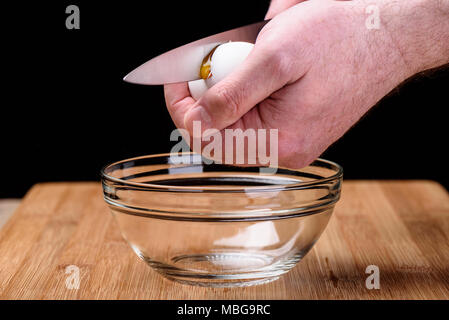 A man is breaking an egg. Chicken egg. Yolk from a broken shell. Stock Photo