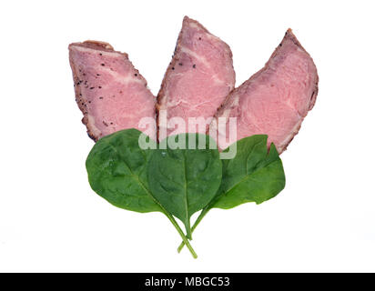 Grass fed juicy corn roast beef with spinach leaves isolated on white background Stock Photo