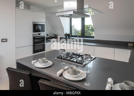 Modern white kitchen with breakfast bar and gothic style window