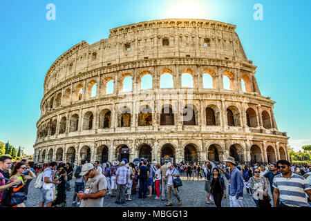 Crowds of tourists wait outside the ancient Colosseum on a sunny afternoon in Rome Italy Stock Photo