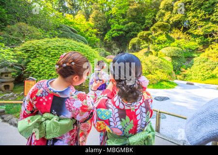 Kamakura, Japan - April 23, 2017: Japanese women wearing Japanese traditional kimono take photo with smartphone at japanese zen garden inside Take-dera Temple in Kamakura. Stock Photo