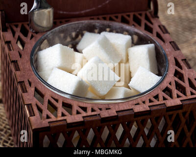 Cubes of sugar in brown wooden carved sugar Stock Photo