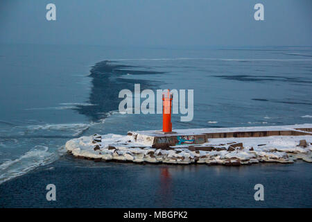 Red Lighthouse on Breakwater Dam in Riga Europe.promenade at Mangalsala Red Lighthouse, Located at Riga Sea Port, Latvia.Winter and frouzen sea in ice Stock Photo