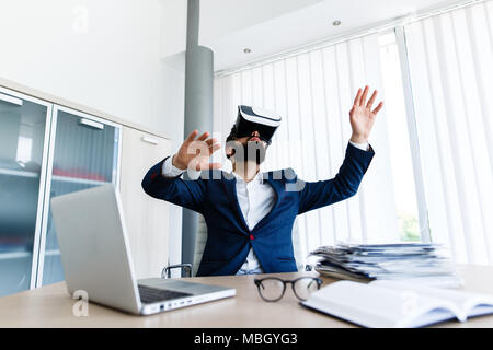 Young Businessman Using VR At Workplace Stock Photo
