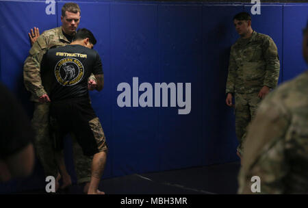 U.S. Army Sgt. Nelson Rodriguez (bottom) assigned to the 55th Signal Company (Combat Camera) performs a wall position on Spc. Casey Dinnison (top) during the Basic Combatives Course at Gaffney Fitness Center located at Fort George G Meade, Maryland, Dec 11, 2017. The Army combatives program enhances unit combat readiness by building Soldiers' personal courage, confidence, and resiliency as well as their situational responsiveness to close quarter threats in the operational environment. Stock Photo