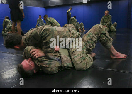 U.S. Army Spc. Christopher Brecht, (top) assigned to the 55th Signal Company (Combat Camera) performs the first step of the arm push and roll to the rear mount technique to Spc. Casey Dinnison (bottom) during the Basic Combatives Course at Gaffney Fitness Center located at Fort George G Meade, Maryland, Dec 13, 2017.The Army combatives program enhances unit combat readiness by building Soldiers' personal courage, confidence, and resiliency as well as their situational responsiveness to close quarter threats in the operational environment. Stock Photo