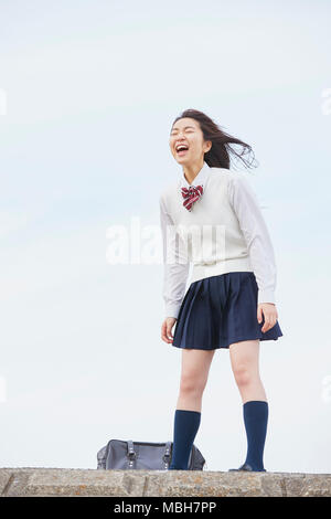 Cute Japanese high school student in a city park Stock Photo