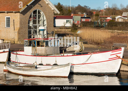 Two white vintage fishing boats moored at harbor in Gronhogen on Oland, Sweden. Names and logos removed. Stock Photo