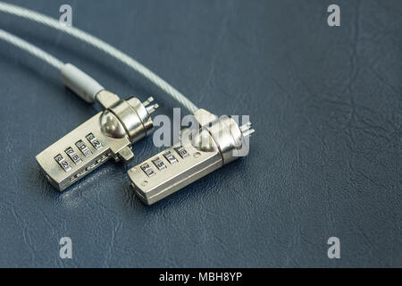 Two computer cable lock on black leather, Security concept shot for the digital age Stock Photo
