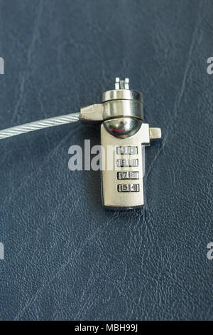 Computer cable lock on black leather, Security concept shot for the digital age Stock Photo