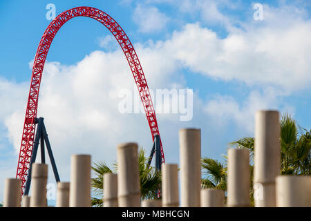 red roller coaster and light brown bamboo with cloudy blue sky