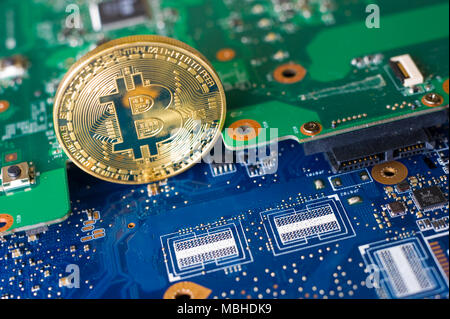 Bitcoin standing on the electronic motherboard of a laptop Stock Photo