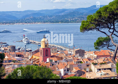 Panoramic view of Saint Tropez, Mediterranean chic fishing village in French Riviera, over roofs of old historical houses, port pier with super yachts Stock Photo