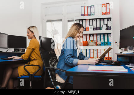 Cheerful women working with computers in the office. Two female programmers working on new project. Stock Photo