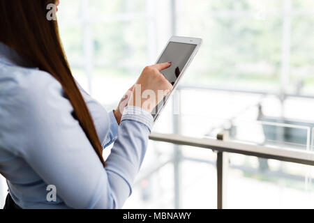 Hands of business woman touching her tablet in modern interior Stock Photo