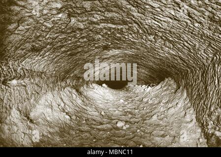 The old sandstone water tunnel, mined caves.  The cave. Sandstone tunnel moistened walls. Dry channel carved in the rocky underground. Solarize effect Stock Photo