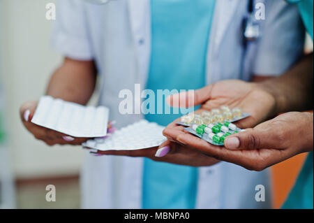 Two african american pharmacist working in drugstore at hospital pharmacy. African healthcare. Close up pills on hands. Stock Photo