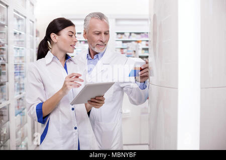 Mature male doctor assisting pharmacist Stock Photo