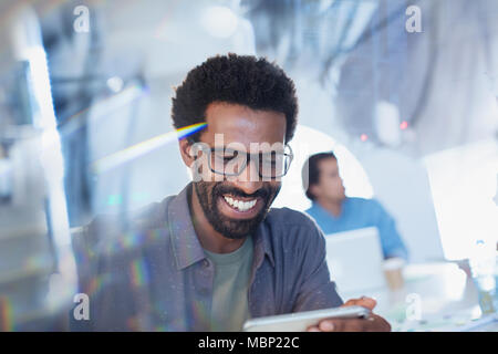 Smiling, confident businessman using digital tablet Stock Photo